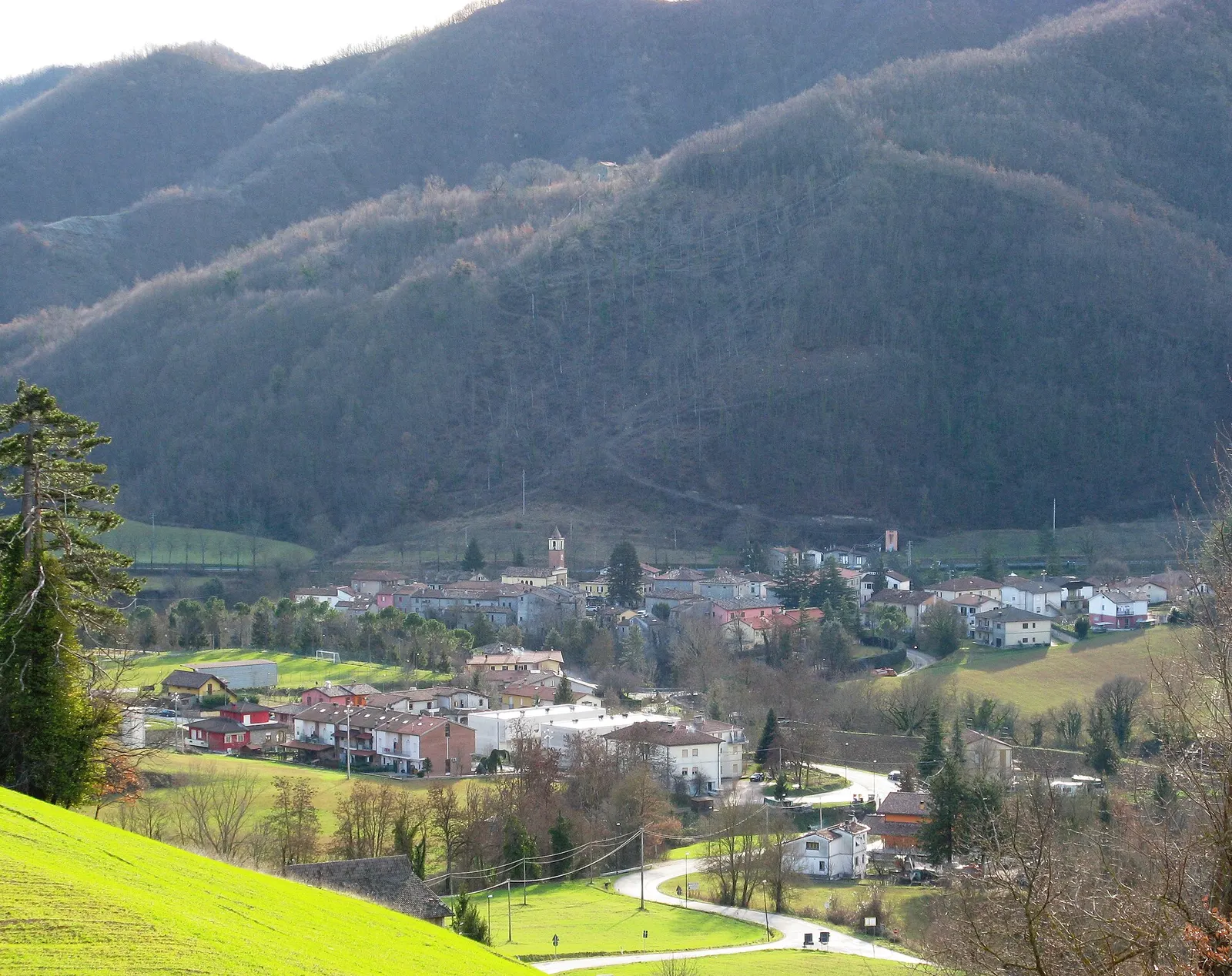Borgo Pace adagiato nella valle tra i monti dell'Appennino marchigiano con campanile e case storiche