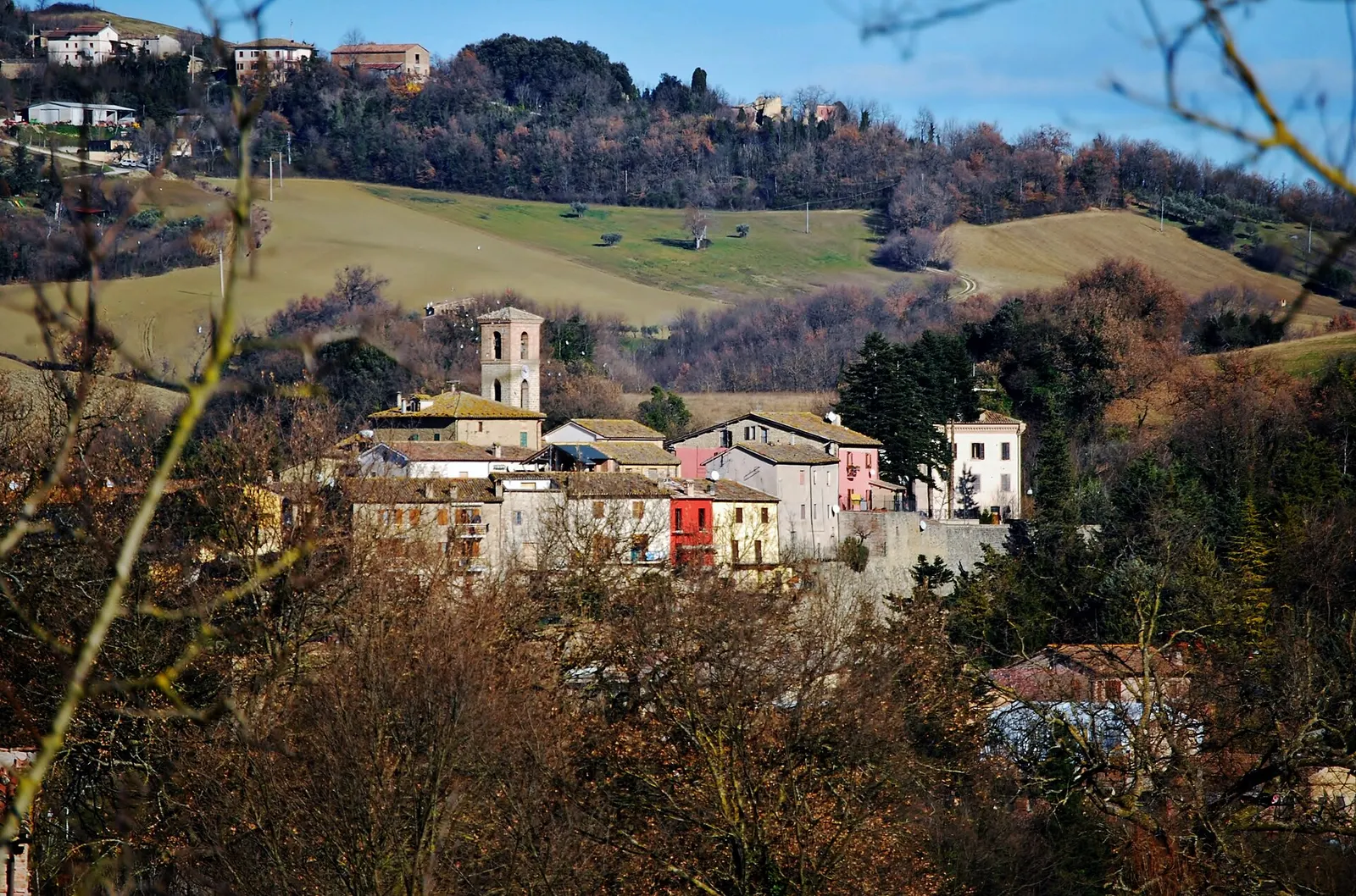 Borgo di Camporotondo di Fiastrone con campanile tra colline marchigiane e case colorate del centro storico