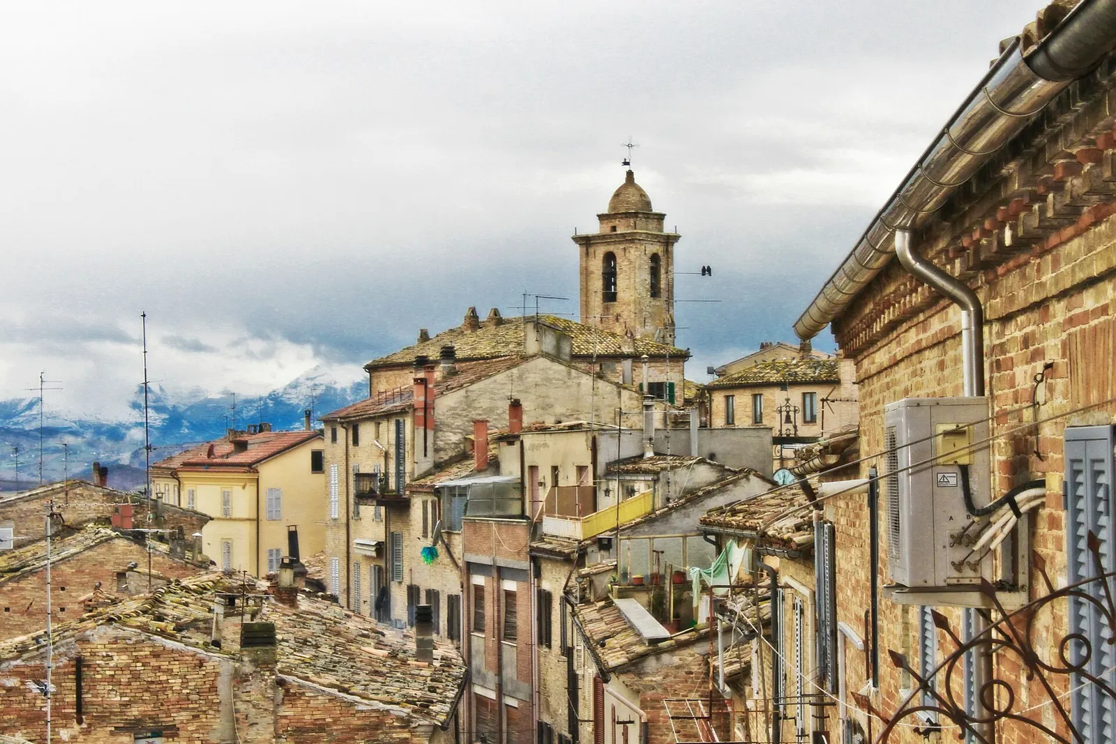 Centro storico di Carassai con campanile della chiesa e tetti in cotto tra le colline marchigiane