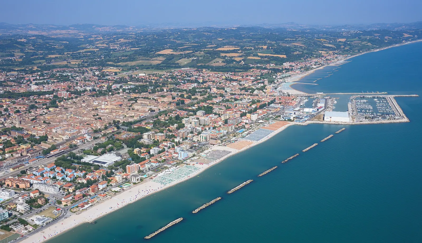 Veduta aerea di Fano con il centro storico, la spiaggia adriatica e il porto turistico sulle Marche