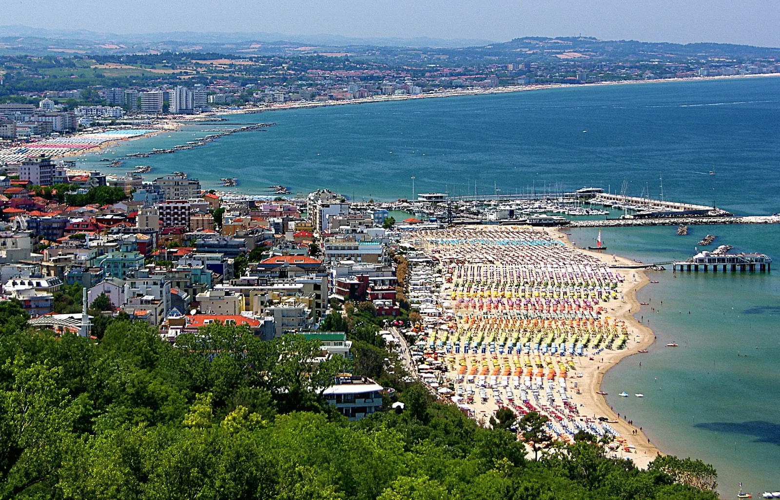 Panorama aereo di Gabicce Mare con spiaggia attrezzata ombrelloni colorati porto turistico e mare Adriatico