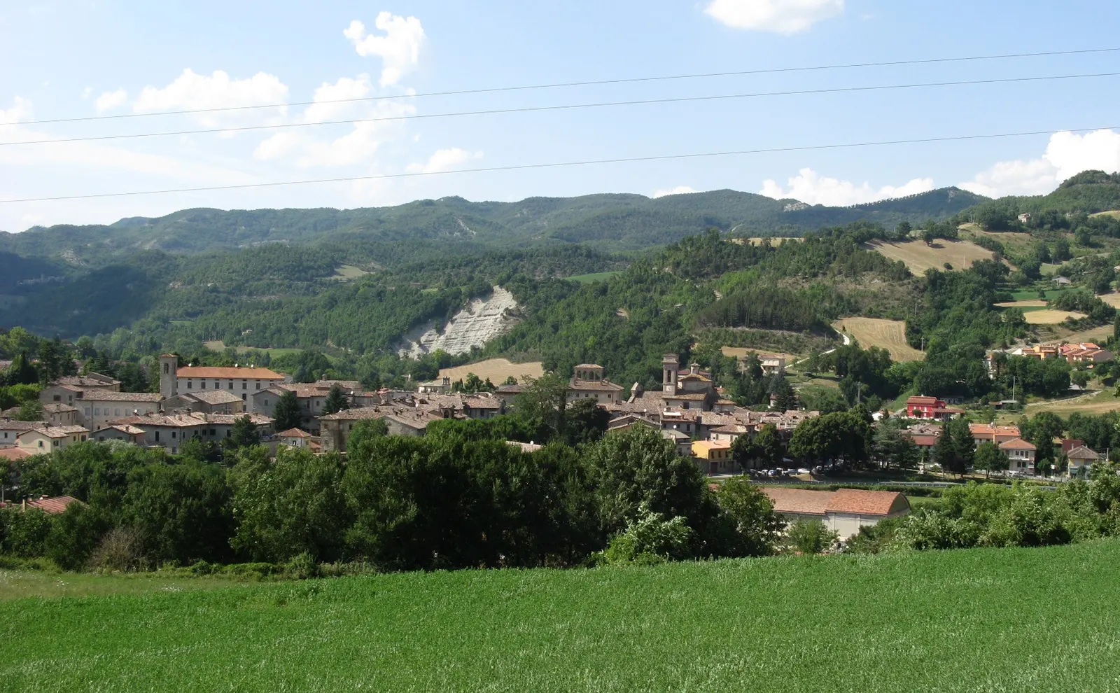 Veduta panoramica di Mercatello sul Metauro con centro storico e colline verdi dell'Appennino marchigiano