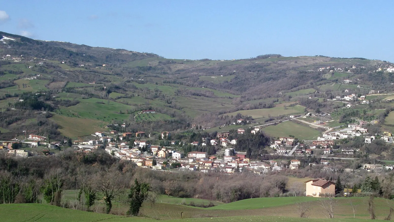 Veduta panoramica di Mercatino Conca tra le dolci colline verdi della Valconca marchigiana