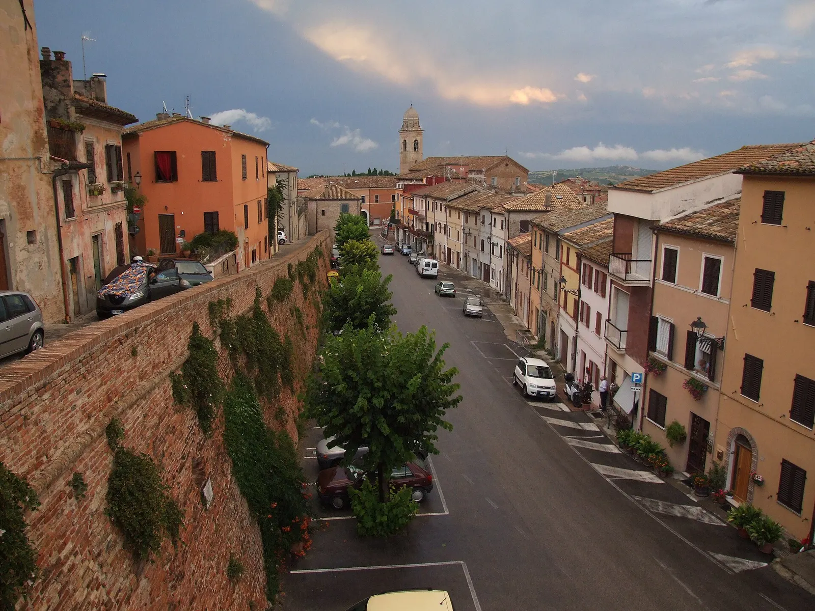 Centro storico di Mondolfo con mura antiche, case colorate e campanile sotto cielo nuvoloso nelle Marche