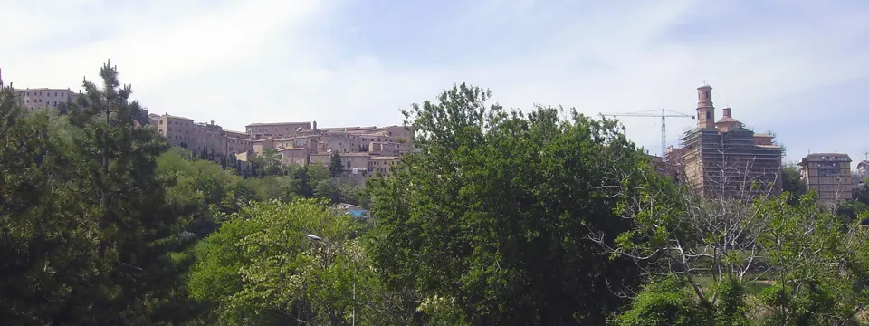 Panorama del centro storico di Montalto delle Marche circondato da verde sotto il cielo delle Marche