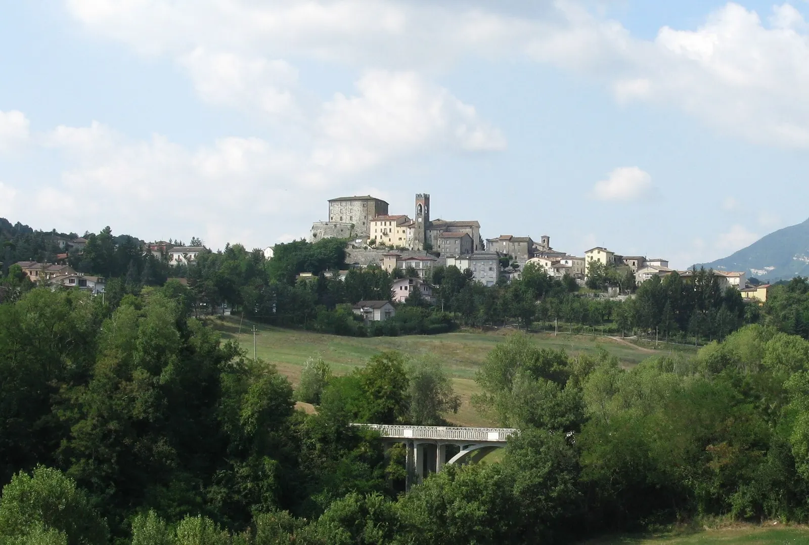 Panorama del borgo medievale di Monte Cerignone su collina con rocca e campanile tra il verde delle Marche