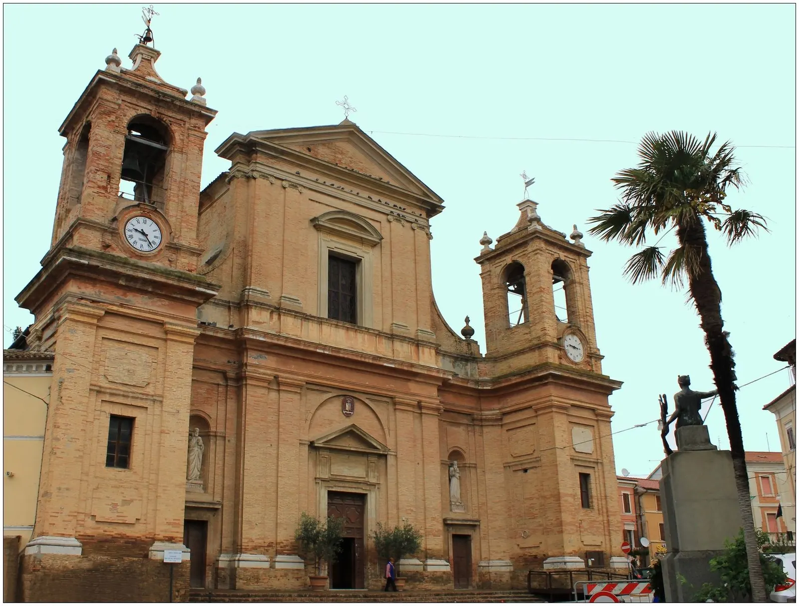 Facciata in mattoni della chiesa storica di Montemarciano con campanile e torre dell'orologio