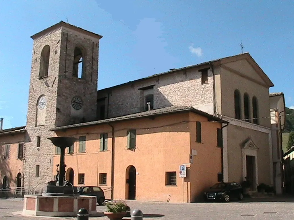Chiesa con campanile in mattoni e piazza del centro storico di Muccia in provincia di Macerata