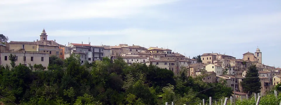 Centro storico di Ortezzano su colle con case in pietra e campanili tra il verde marchigiano