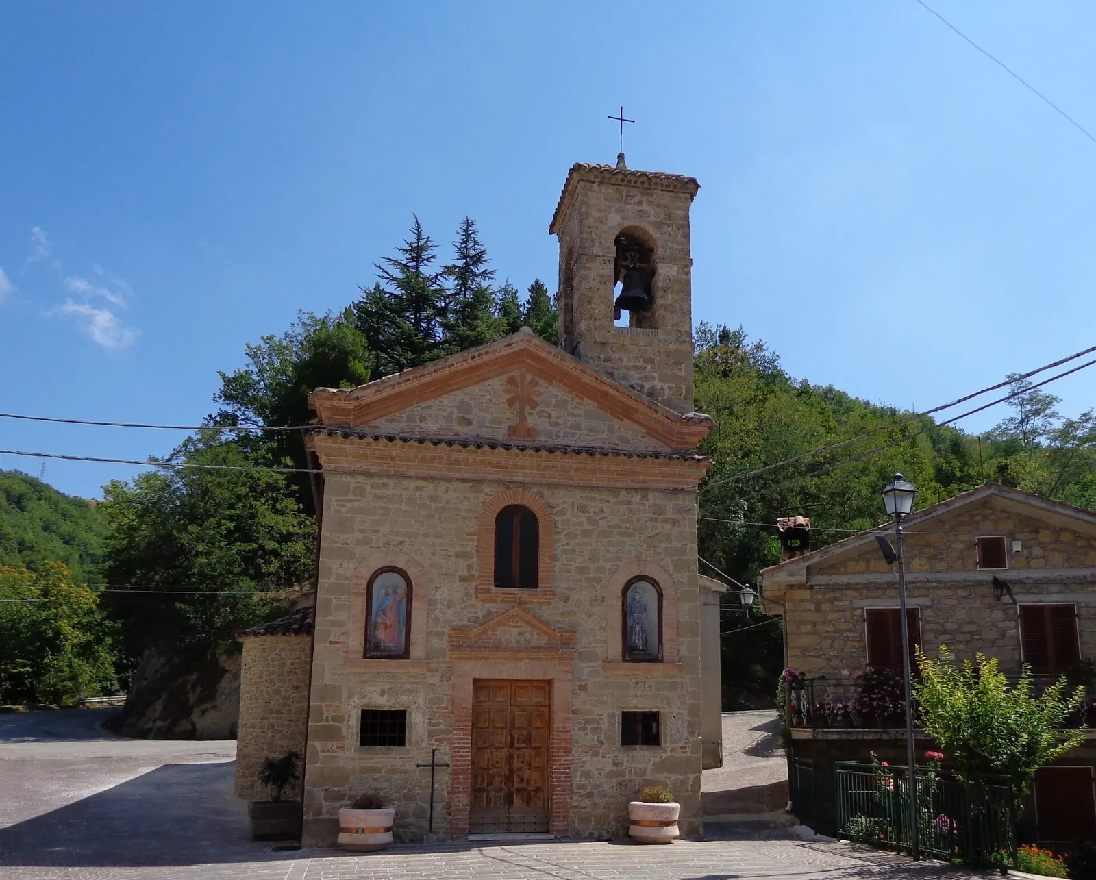Chiesa in pietra con campanile a vela nel borgo collinare di Palmiano in provincia di Ascoli Piceno