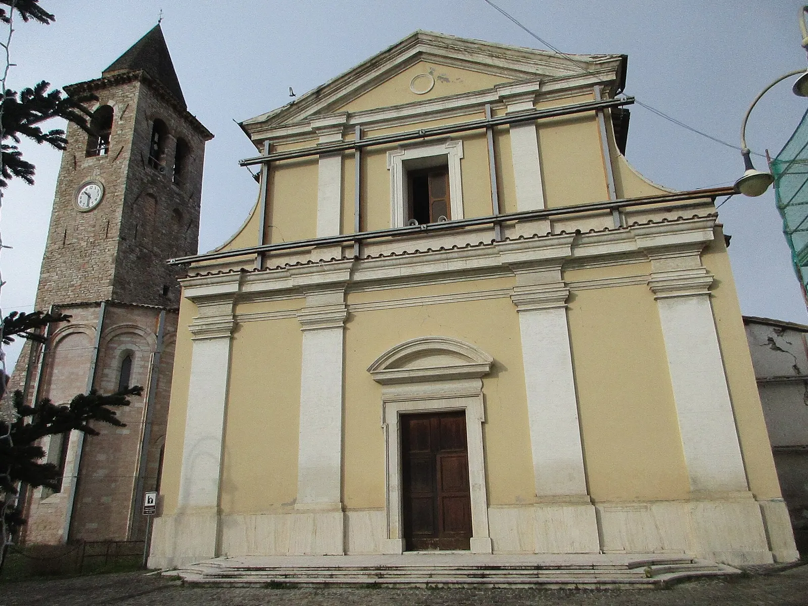 Chiesa con facciata gialla e campanile in pietra nel centro storico di Pieve Torina