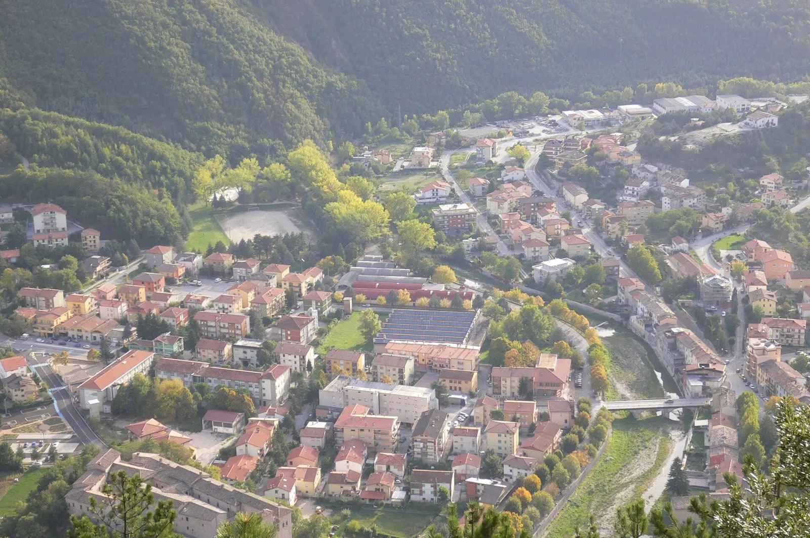 Veduta aerea del borgo di Piobbico circondato dai verdi monti dell'Appennino marchigiano