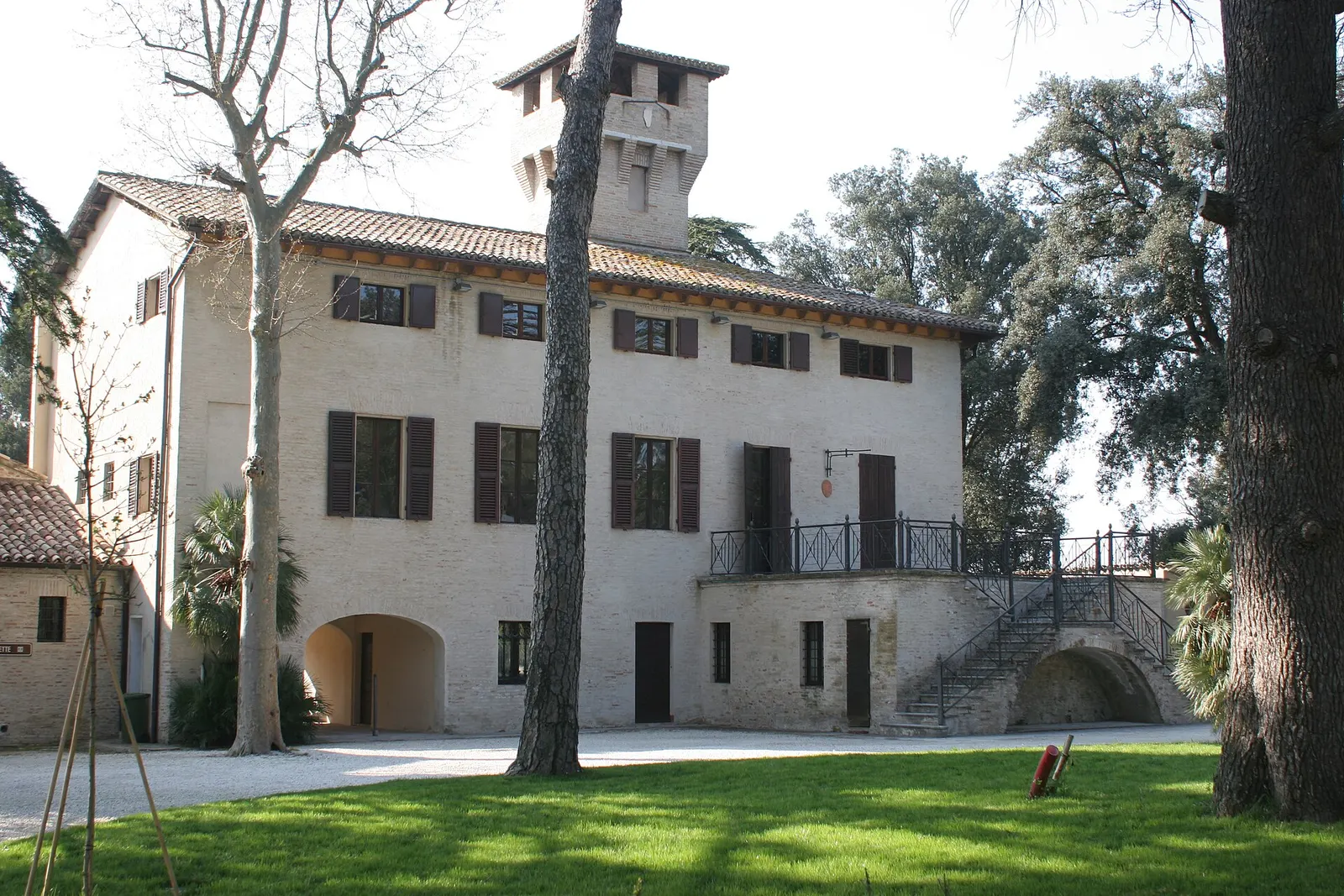 Villa storica con torre e scalinata esterna circondata da verde nel borgo di Polverigi nelle Marche