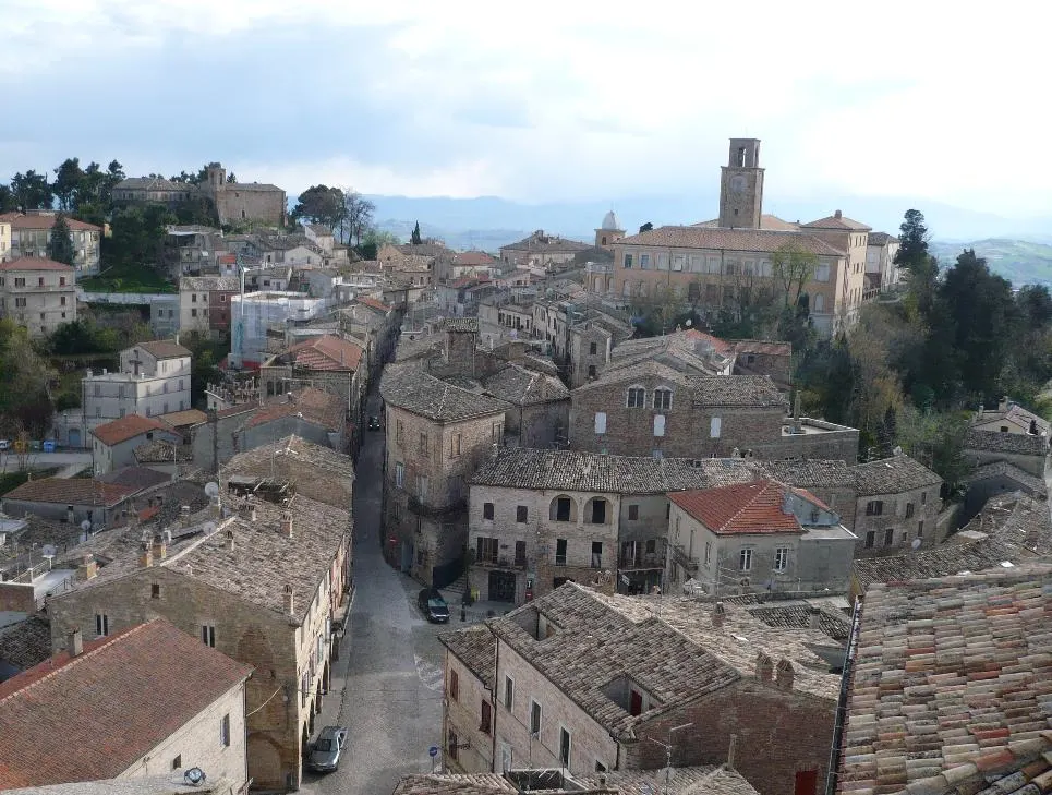 Veduta aerea del borgo storico del Piceno con case in pietra e campanile sullo sfondo delle colline marchigiane