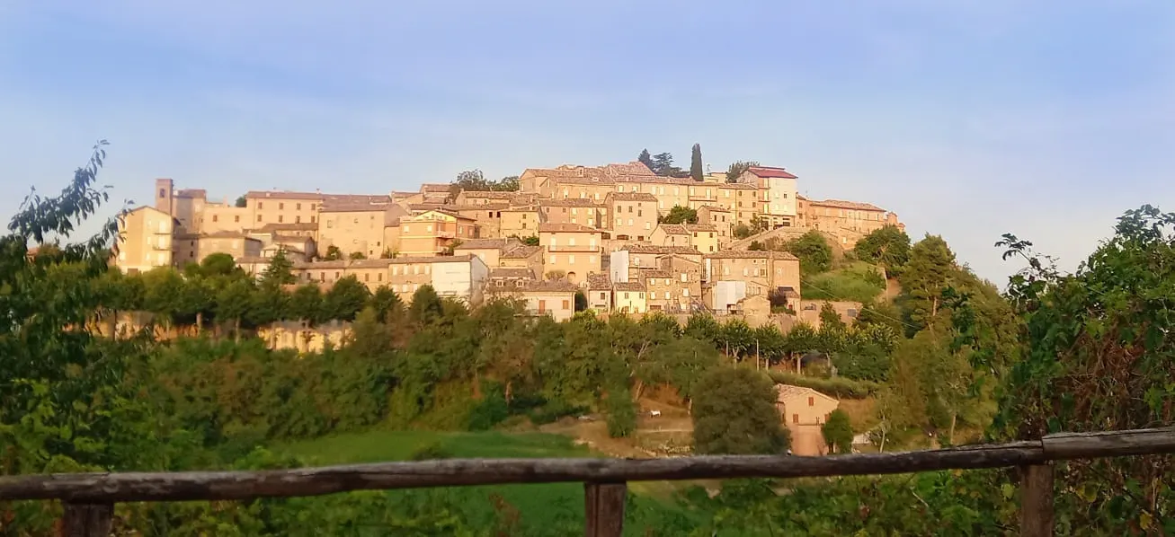 Panorama del borgo medievale di Sant'Angelo in Pontano su una collina tra il verde delle Marche