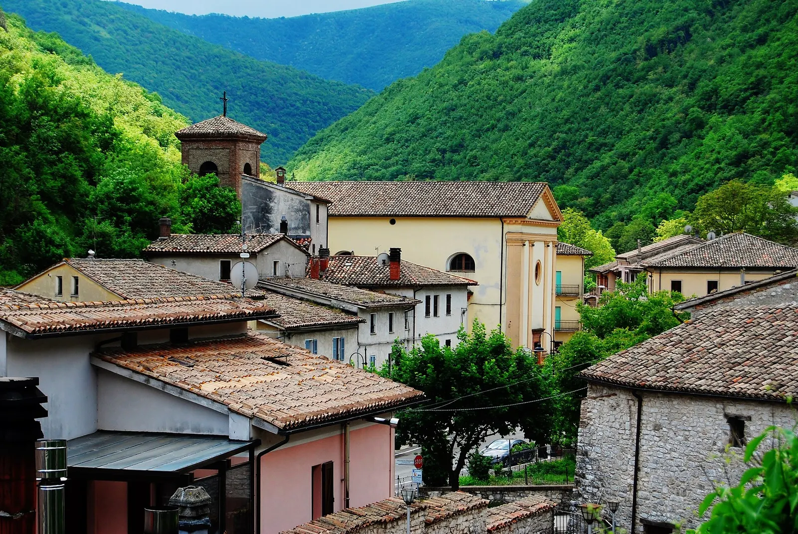 Centro storico di Sefro con campanile e case tra le montagne verdi dell'Appennino marchigiano