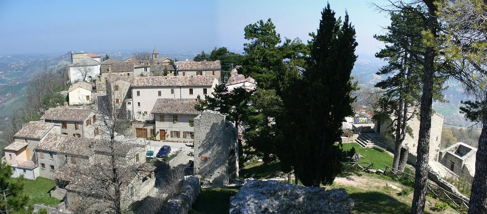 Borgo medievale di Smerillo arroccato sulle colline marchigiane con case in pietra e cipressi secolari
