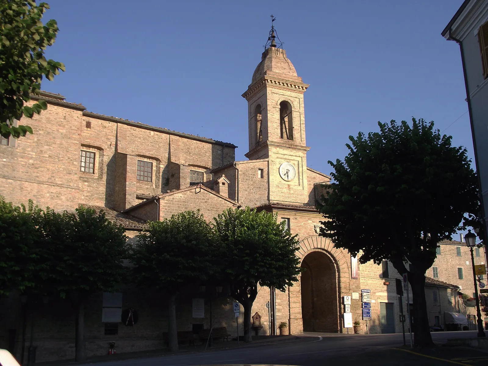 Chiesa con campanile e piazza alberata nel centro storico di Staffolo nelle Marche