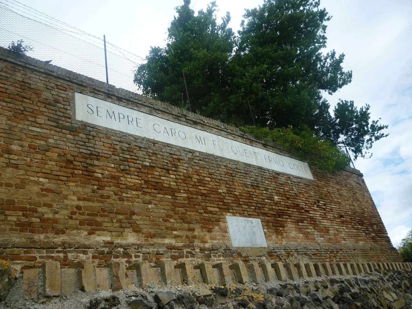 Muro in mattoni con verso leopardiano Sempre caro mi fu a Recanati nelle Marche