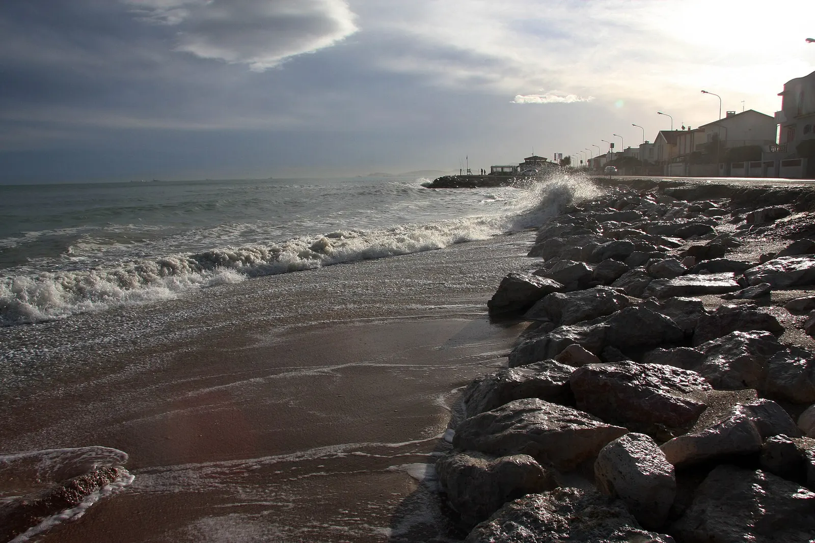 Spiaggia di Marzocca con scogliera e onde del mare Adriatico al tramonto vicino Senigallia