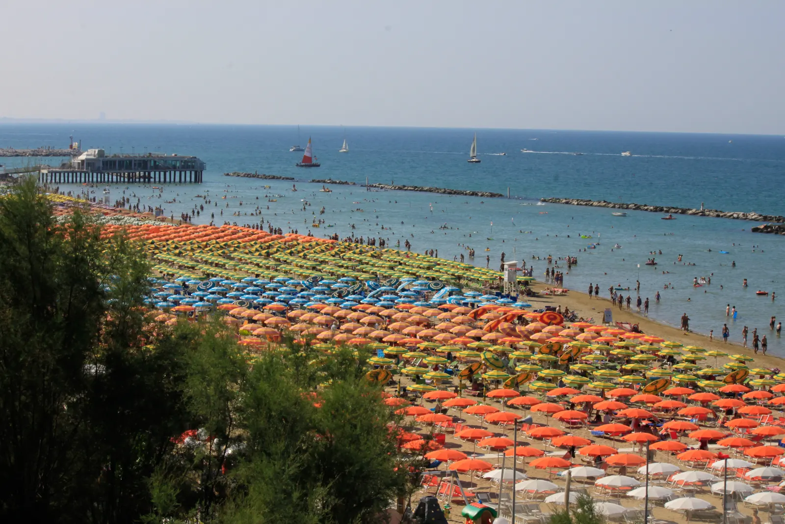 Veduta dall'alto della spiaggia di Gabicce Mare con ombrelloni colorati e bagnanti nel mare Adriatico