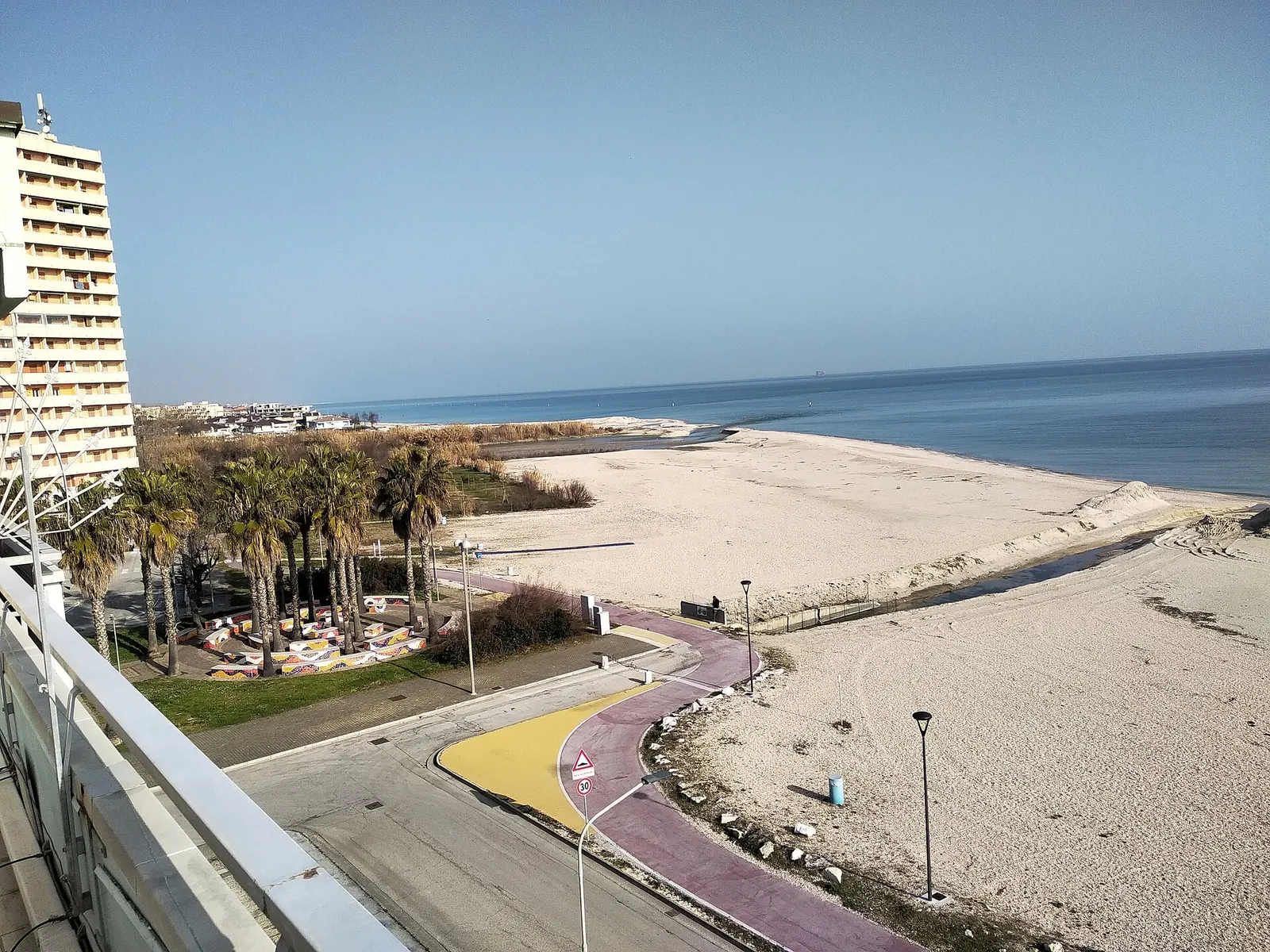 Lungomare e spiaggia sabbiosa di Lido di Fermo con mare Adriatico e palme lungo la costa marchigiana