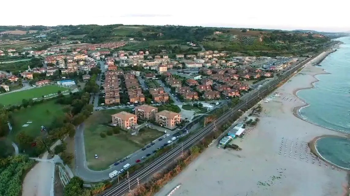 Vista aerea di Marina di Altidona con ferrovia costiera, spiaggia adriatica e colline verdi marchigiane