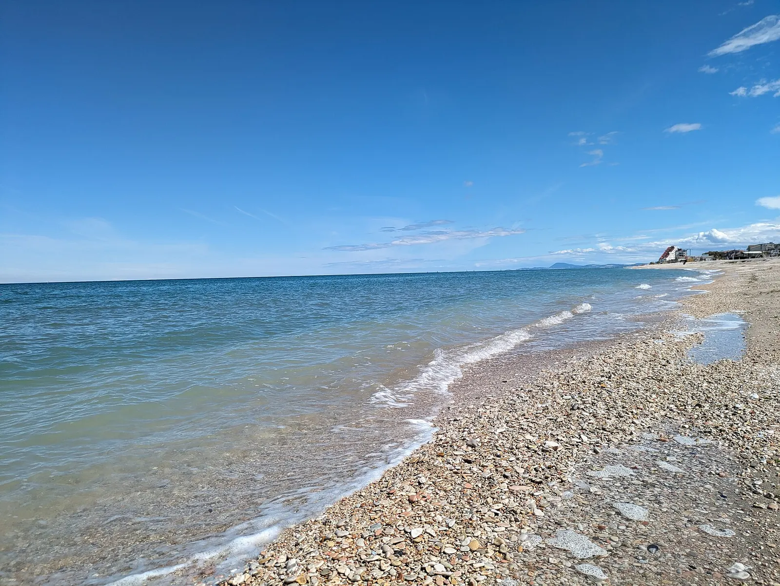 Spiaggia di ciottoli e mare Adriatico cristallino a Marotta di Mondolfo nelle Marche