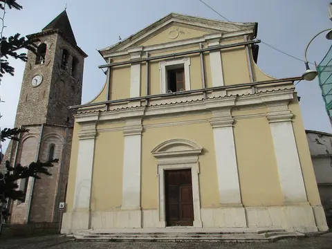 Chiesa con facciata gialla e campanile in pietra nel centro storico di Pieve Torina