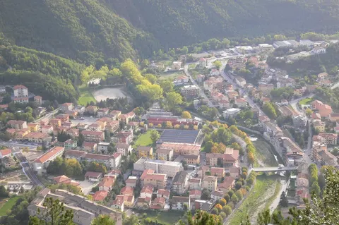Veduta aerea del borgo di Piobbico circondato dai verdi monti dell'Appennino marchigiano